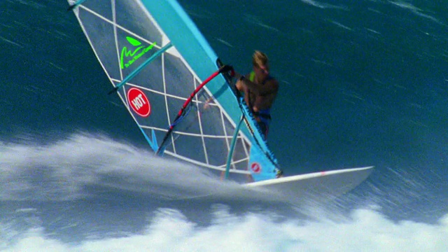 空中追踪拍摄到一名男性风帆冲浪者在夏威夷的海洋上冲浪视频素材
