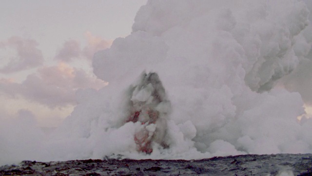 在前景/基拉韦厄火山，夏威夷，白色烟雾与红色熔岩/黑色熔岩爆炸视频素材