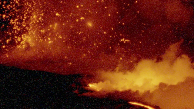 夏威夷基拉韦厄火山爆发的火红熔岩在黑色的表面上发光，带着橙色的烟雾视频素材