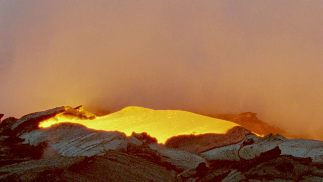 近距离观察夏威夷基拉韦厄火山，炽热的熔岩在黑色熔岩顶部流动，喷出浓烟视频素材