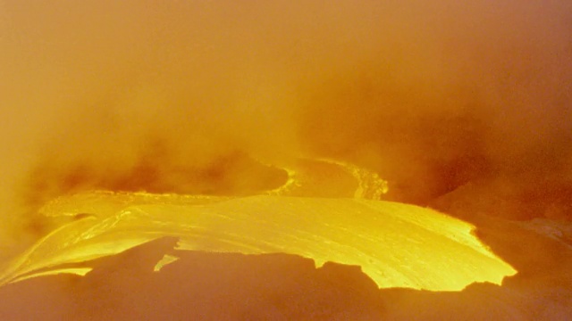 近距离观察夏威夷基拉韦厄火山炽热的熔岩流和橙色的烟雾视频素材