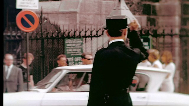 20世纪60年代，法国巴黎，警察用棍子指挥交通/行人在人行道上行走视频下载