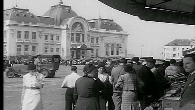 20世纪30年代，法国的特鲁维尔(海边的特鲁维尔)，人们走路+看着户外小贩的摊位/背景中的特鲁维尔赌场便门视频下载