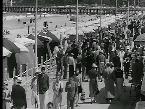 法国诺曼底BG/多维尔的木板路/海洋+海滩上，20世纪30年代的高角度人群视频下载