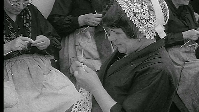 20世纪30年代的妇女在传统的花边帽钩针花边/其他妇女在背景/布列塔尼，法国视频下载