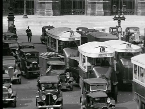 1927年，法国巴黎歌剧院广场，高角度繁忙的十字路口，汽车和公交车缓慢移动视频素材
