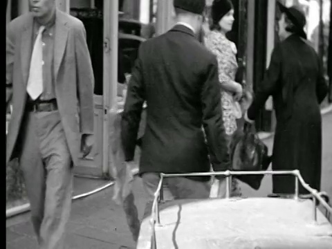 1927年，PAN女士拿着长棍面包离开商店+走在人行道上/法国巴黎视频下载