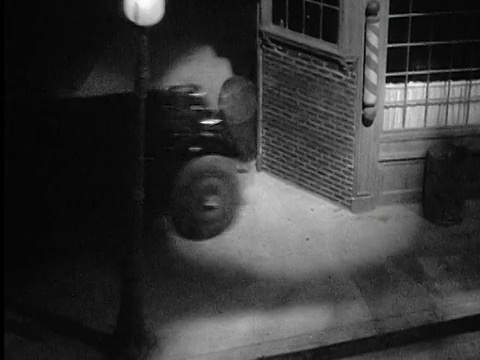 一辆20世纪20年代/30年代的高角度汽车在晚上撞进理发店视频素材