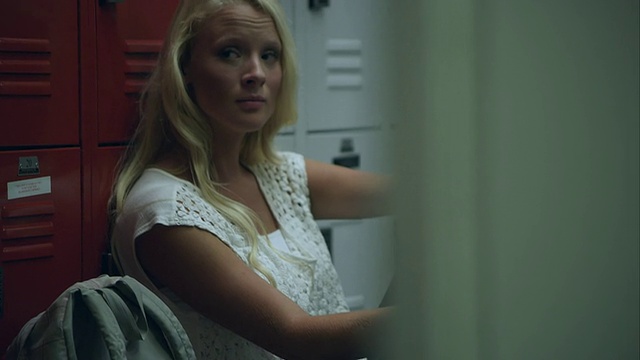慢镜头拍摄少女坐在储物柜旁左臂缺了一部分。视频素材