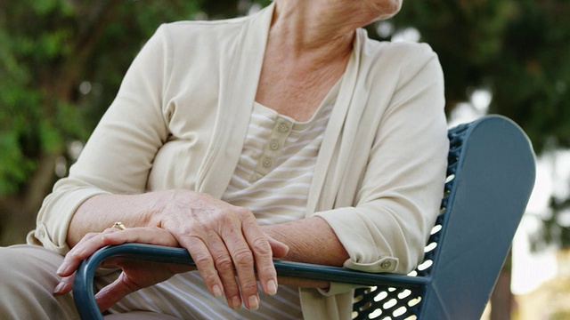 老女人坐在公园长椅上思考视频素材