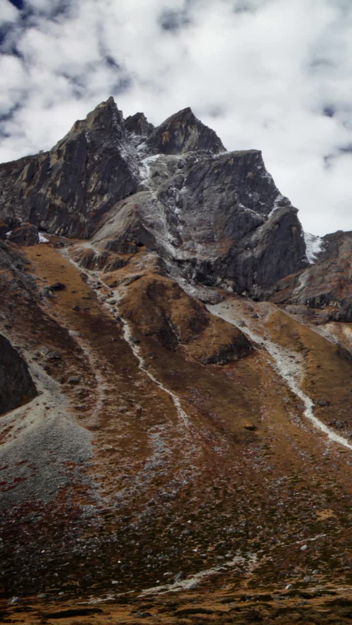 垂直拍摄的岩石喜马拉雅山峰和路过的云延时。视频素材
