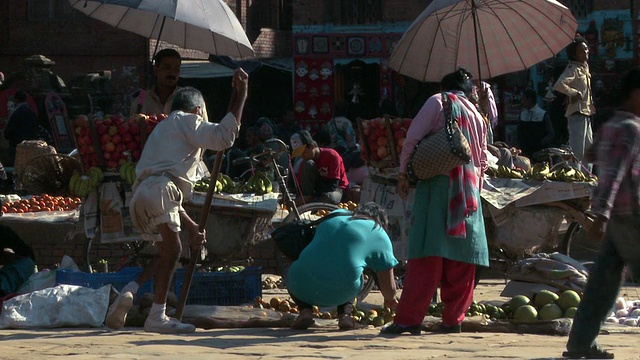 一名拄着拐杖的男子穿过尼泊尔的一个市场。视频素材