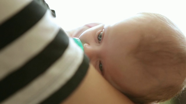 一个年轻男子抱着一个漂亮的婴儿的近距离静态镜头。视频素材