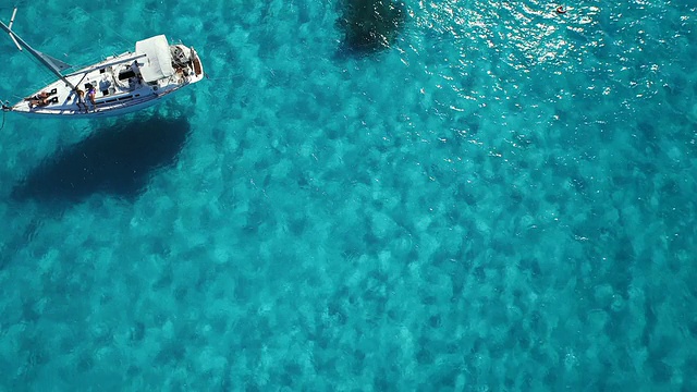航拍向下看飞过帆船停泊在美丽的清澈的蓝色海洋视频素材