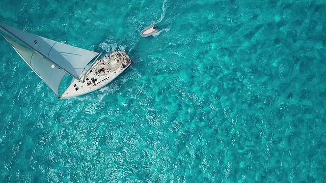 航拍帆船驶向美丽清澈的蓝色热带海洋的相机视频素材