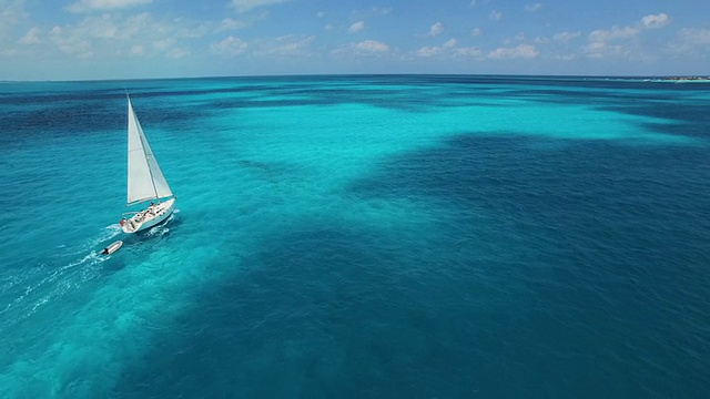 航拍帆船航行到美丽清澈的蓝色热带海洋的地平线上视频下载