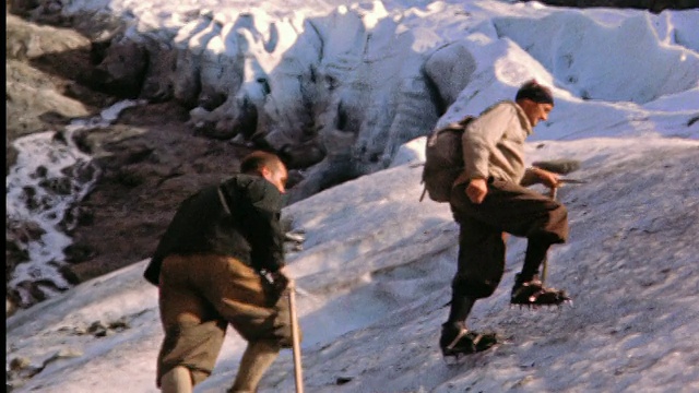 20世纪50年代，两名男子穿着冰爪，手持镐爬上意大利阿尔卑斯山的冰坡视频下载