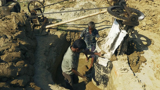 在孟加拉国，人们挖泥土和粘土，并与水混合，再由机器搅拌，以准备制砖视频下载