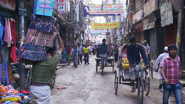孟加拉国达卡老城区拥挤的小巷和街道上熙熙攘攘的行人和人力车视频下载