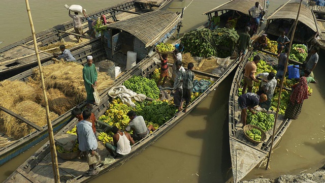 在每月一次色彩缤纷的集市上，家庭和商人们乘船聚集在一起，以物易物的方式出售和接触孟加拉国农村的当地产品和供应品视频下载