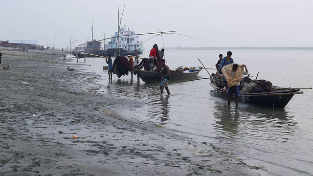 日落时分，渔夫们回到孟加拉国贾穆纳河的岸边，卸下拍卖的货物，分享他们捕到的小鱼，然后整理渔网回家视频下载