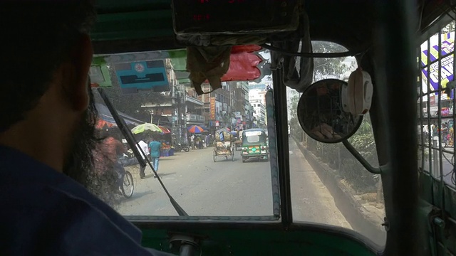 在孟加拉国达卡繁忙的街道上，一辆关在笼子里的机动三轮车发出疯狂的噪音，让人产生幽闭恐惧症视频下载