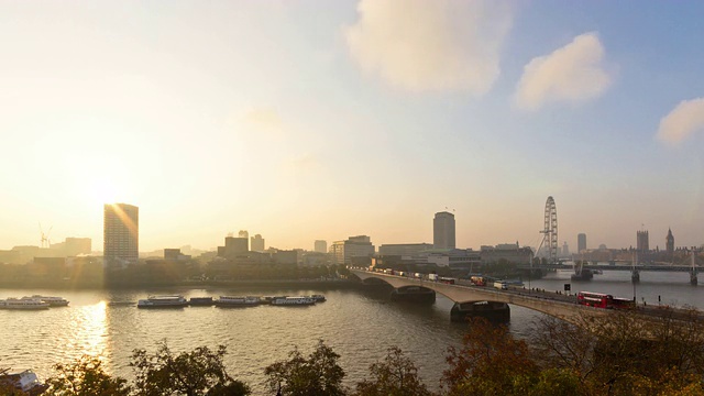 时间流逝的伦敦和泰晤士河与日出从萨默塞特宫的屋顶拍摄的千禧轮、滑铁卢桥、威斯敏斯特和船只交通视频下载