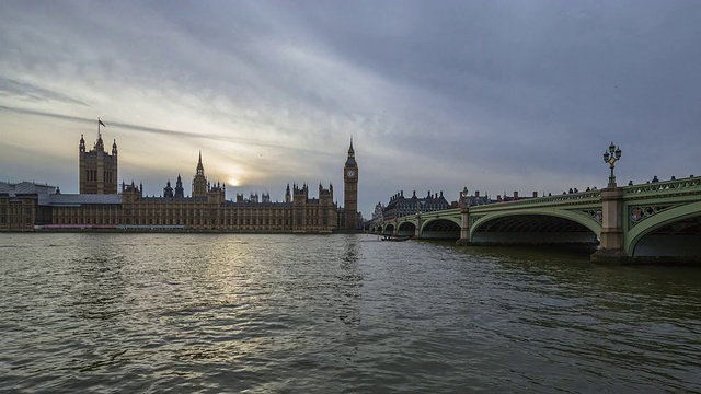 英国议会大厦和威斯敏斯特大桥的时间流逝从白天日落到夜晚显示河流和道路交通视频下载