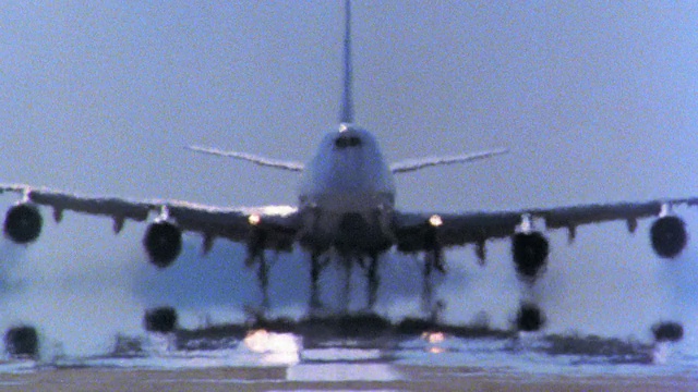 747喷气式飞机向摄像机靠近，飞机前有热浪从跑道起飞/向上倾斜视频下载