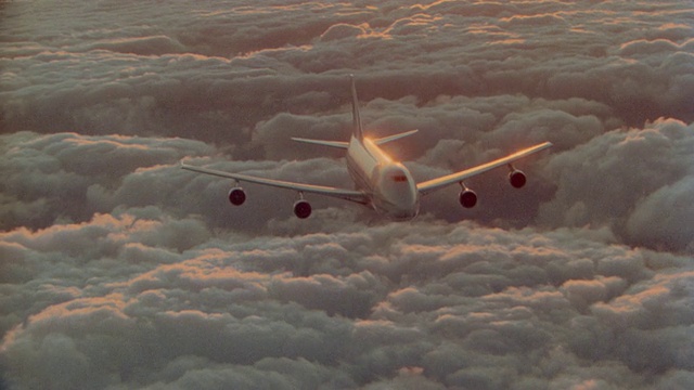 空中高角度飞机视角约747喷气式飞机在日落/升起的橙色云海上空飞行视频素材