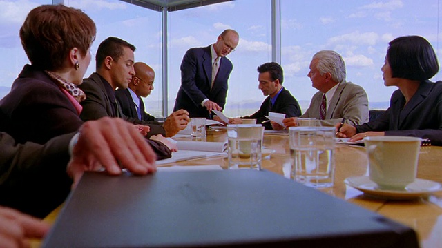 双手合上，打开桌上/机架上的笔记本电脑，专注于坐在桌子上的人在商业会议中交谈的背景视频下载