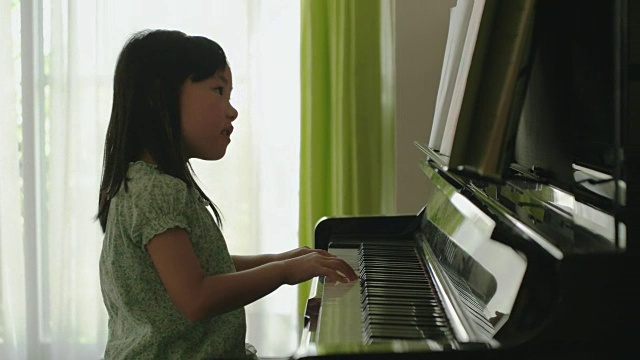 日本女孩在家里弹钢琴。视频下载