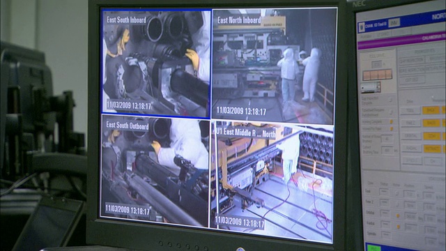 一个安全监视器在两个电脑屏幕附近显示四个摄像头的视图。视频下载