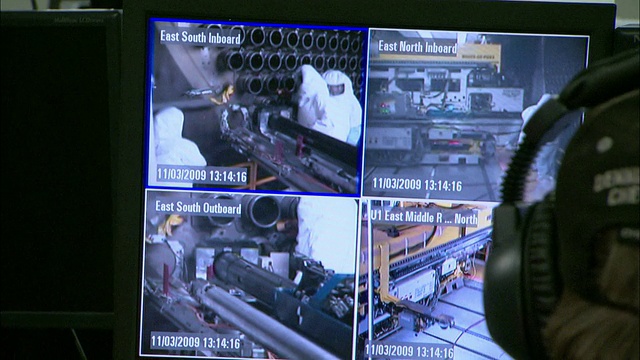 一名技术人员用不同的摄像头观察两个安全监视器。视频下载