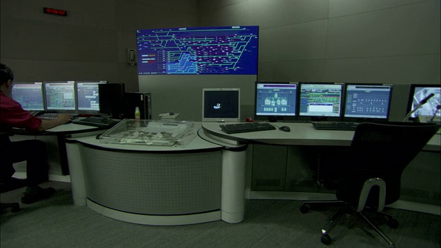 技术人员在控制室里操作电脑和监控数据。视频下载