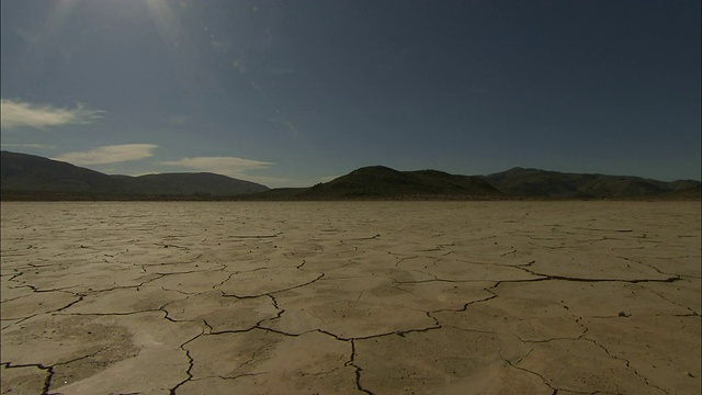 干涸的湖床后面是多山的地平线。视频素材
