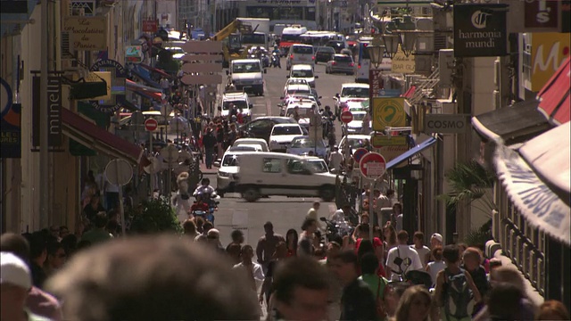 汽车和行人拥挤在马赛零售区的一条繁忙街道上。视频下载