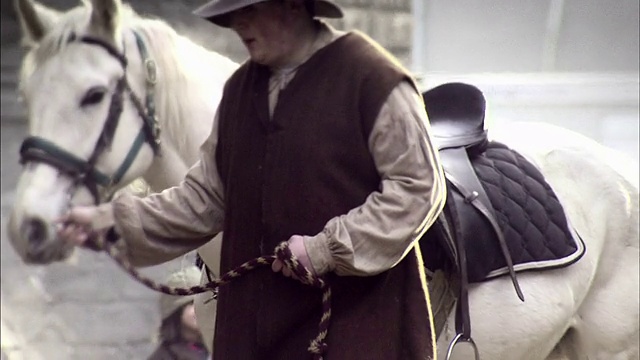 一个人牵着他的马穿过热闹的伦敦市场。视频素材