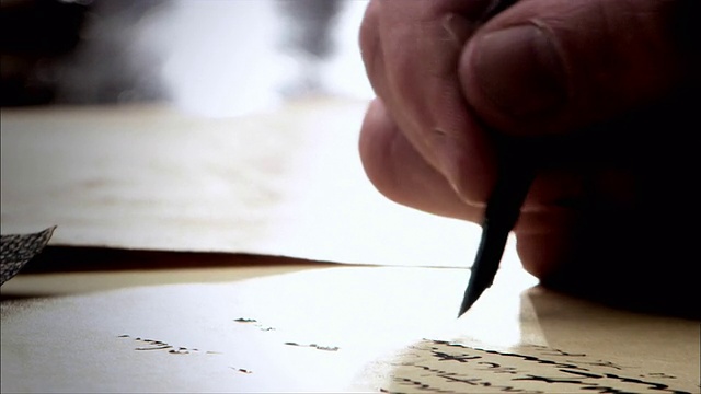 一只手用羽毛笔在纸上写字。视频下载