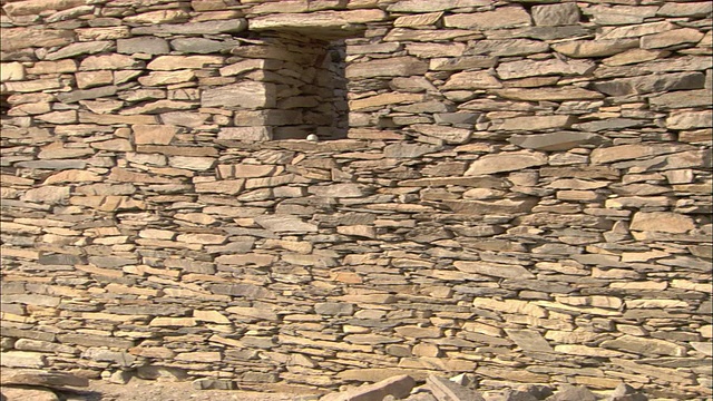 阴影落在由石头堆叠而成的古老建筑上。视频素材