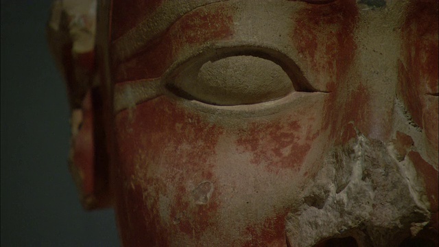 一尊埃及雕像的脸被旧的红油漆染得斑驳。视频素材