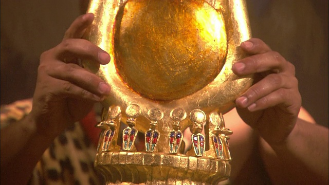 一双手把一顶带翅膀的金王冠放在克利奥帕特拉的头上。视频素材