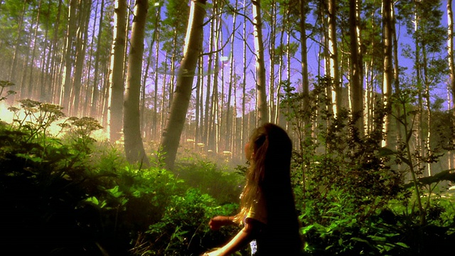 慢镜头巨大的气泡通过女孩的头，因为她弹出它在茂密的森林/阿斯彭，CO视频素材
