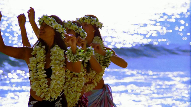 三名草裙舞女站在一起做手臂动作/海洋背景/夏威夷视频下载