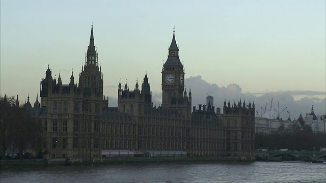 阴沉的天空勾勒出英国伦敦泰晤士河对岸的大本钟和国会大厦。视频素材