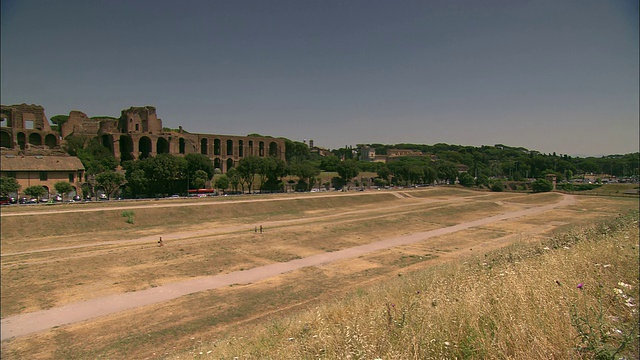 行人穿过意大利罗马竞技场的一片空地。视频下载