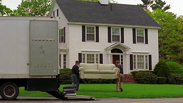 两个人从移动的卡车上卸下沙发，朝房子走去视频下载