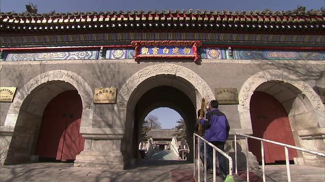行人穿过北京的一个拱形入口。视频下载