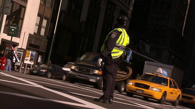 一名交警在纽约市指挥出租车和其他繁忙的交通。视频素材