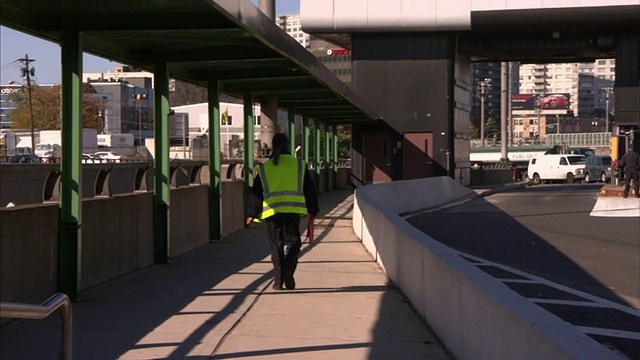 收费站的工作人员穿着安全背心走向收费站。视频素材